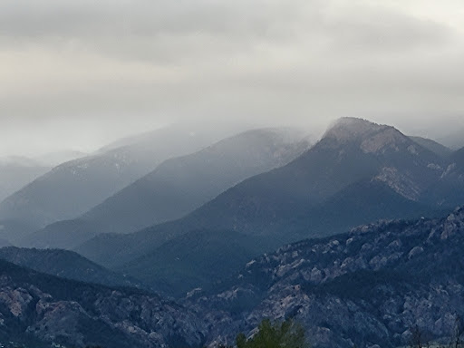 A serene view of mist-covered mountains under a cloudy sky.