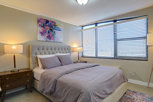 A cozy and modern bedroom featuring a comfortable bed, elegant decor, and natural light streaming in through the windows.