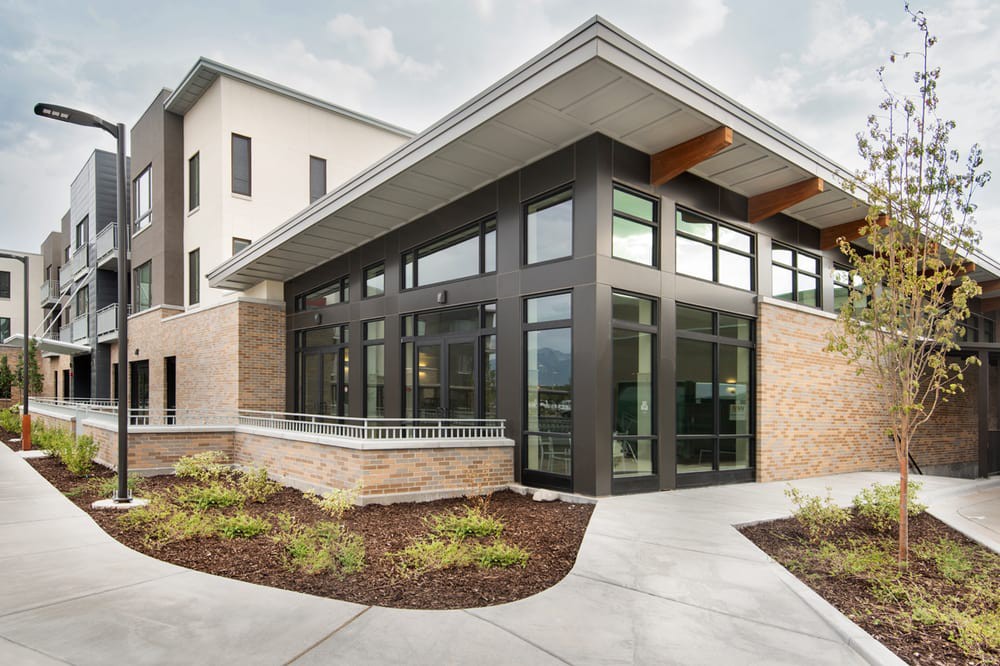 A modern commercial building with large glass windows and landscaped surroundings.