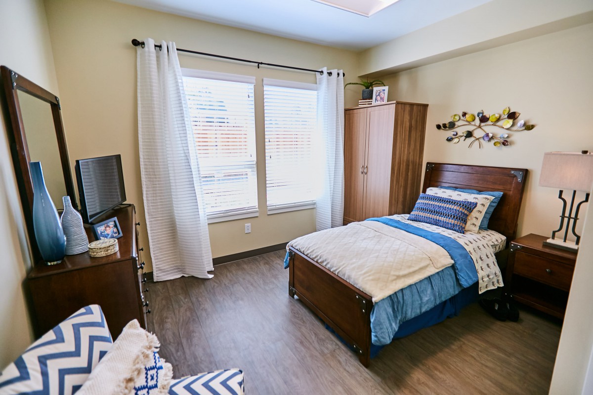 A cozy and well-lit bedroom with a single bed and modern furnishings.