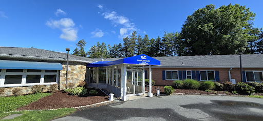 A welcoming entrance with a blue canopy surrounded by greenery.