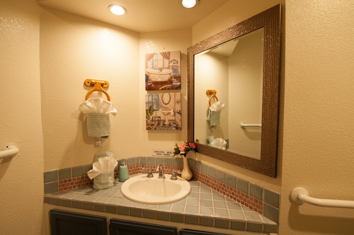 A neatly designed bathroom with a mirror, sink, and decorative elements.