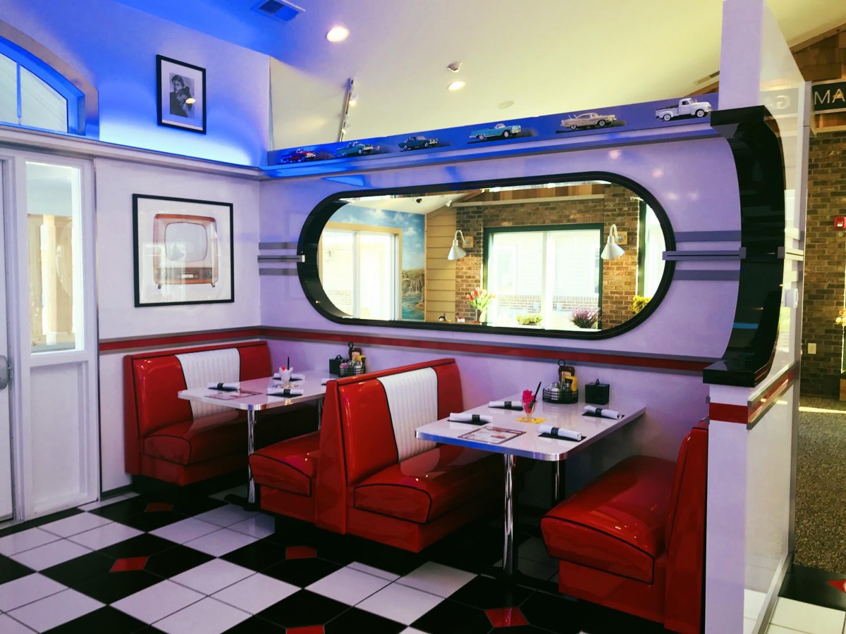 A cozy retro diner with red booth seating and vintage decor.