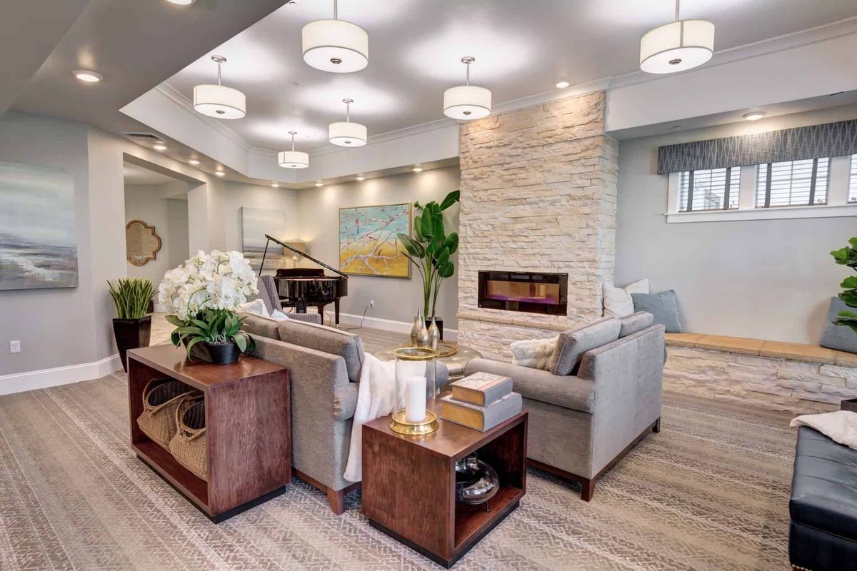 A modern living room featuring a cozy seating area, elegant lighting, and a grand piano.