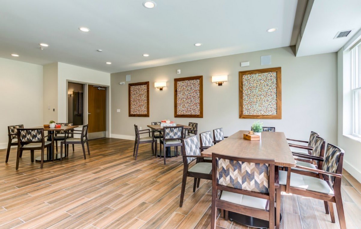 A modern dining area featuring wooden floors, stylish chairs, and decorative wall art.