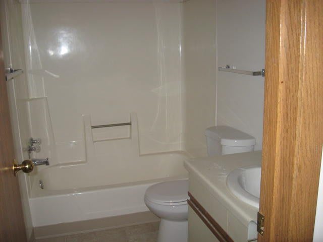 A small bathroom with a bathtub, toilet, and sink.