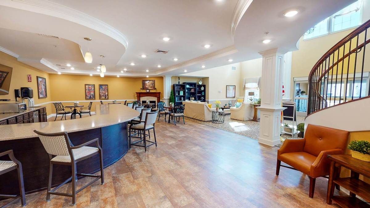 A modern interior lounge featuring a spacious seating area and a bar.