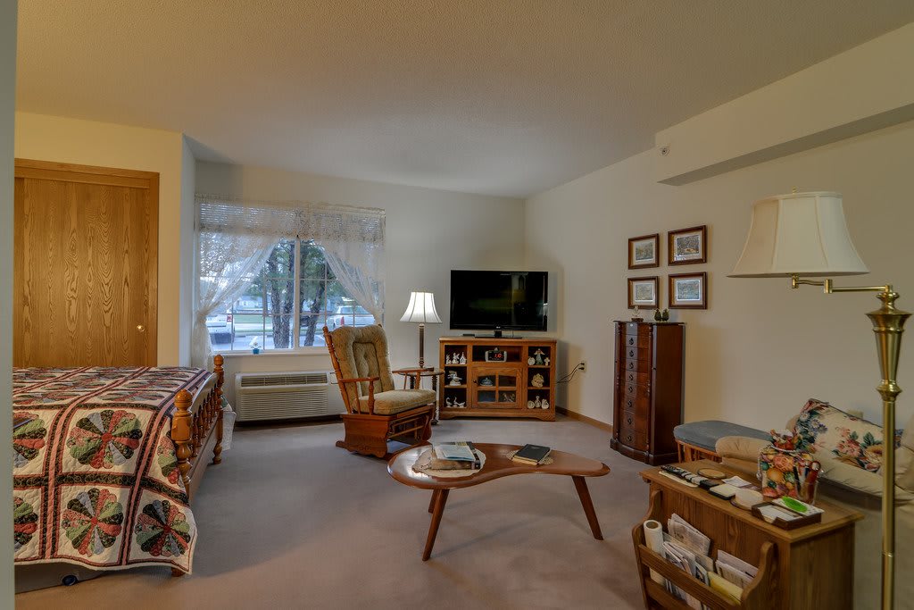 A cozy living room with a TV, coffee table, and comfortable seating.