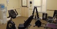 A small gym area with exercise equipment, including a stationary bike and weights.