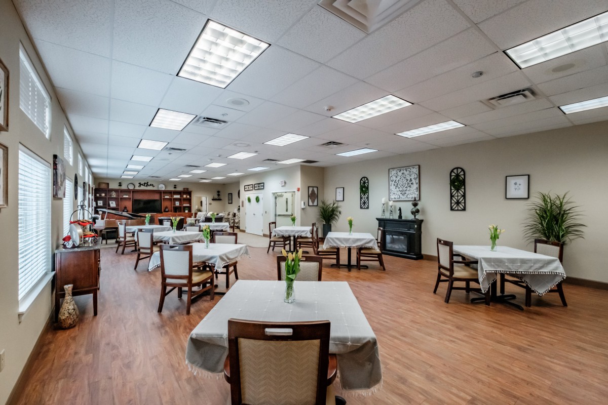 A spacious dining room with neatly arranged tables and chairs, featuring elegant decor and warm lighting.
