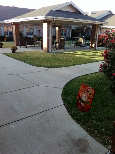A landscaped garden space featuring a winding pathway and decorative sign.