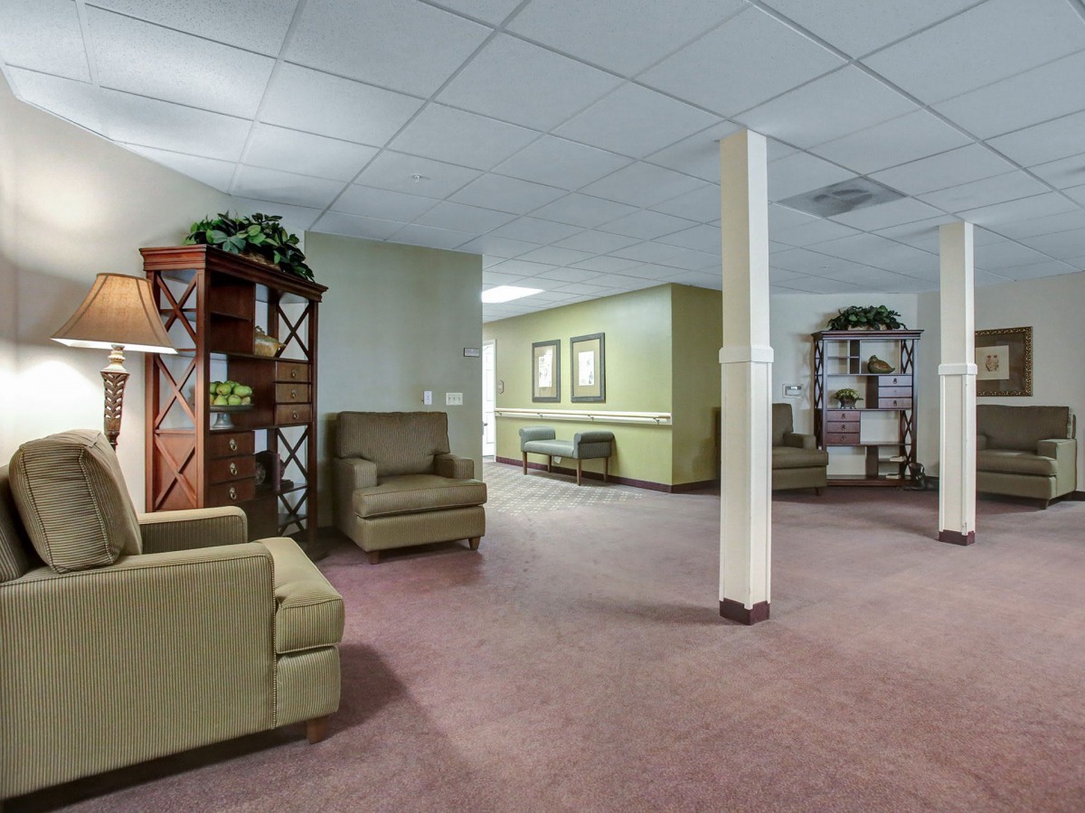 A spacious waiting room featuring comfortable chairs and decorative indoor plants.
