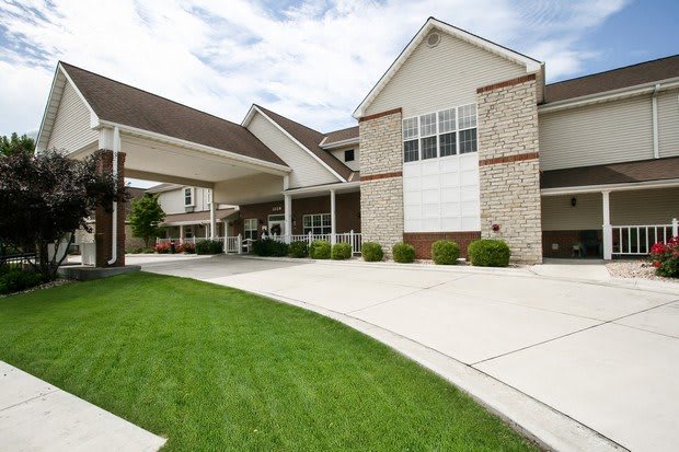 A modern residential building with a driveway and well-maintained lawn.