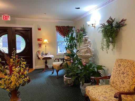 A cozy lobby area adorned with elegant furniture, lush plants, and soft lighting.