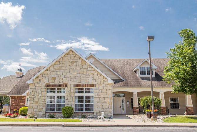 A suburban house with a stone exterior under a clear blue sky.