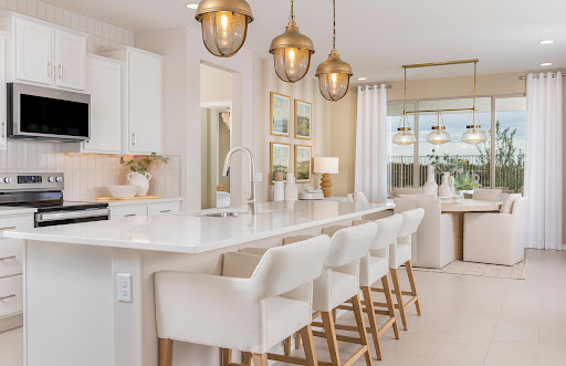 A modern kitchen featuring elegant pendant lighting and stylish bar stools, creating a bright and inviting atmosphere.
