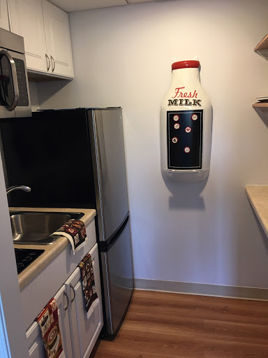 A cozy kitchen featuring modern appliances and a unique milk dispenser.