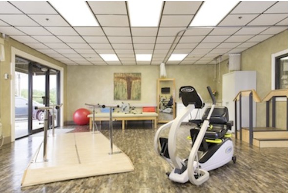 A rehabilitation clinic equipped with various exercise equipment and therapy tools.