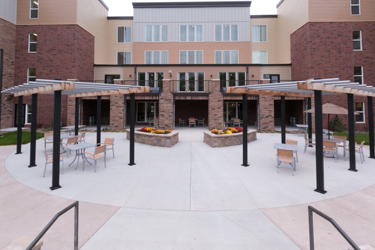 A modern building with a courtyard featuring outdoor seating areas.