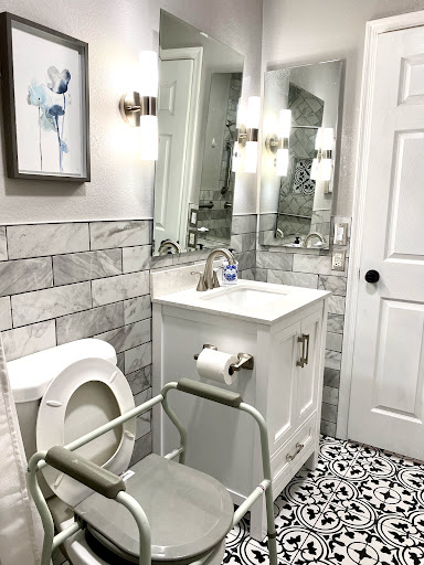 A modern bathroom featuring elegant tiles, a stylish vanity, and functional lighting.