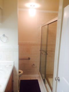 A clean bathroom featuring a glass-enclosed shower and a sink.