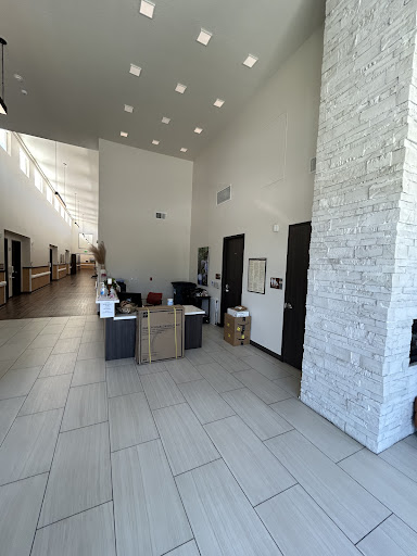 A spacious and modern lobby with a reception area featuring minimalist design and natural light.
