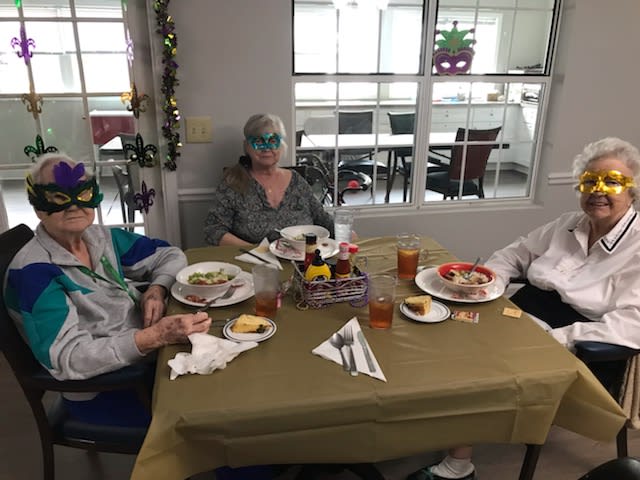 Three people enjoying a meal together at a decorated table.