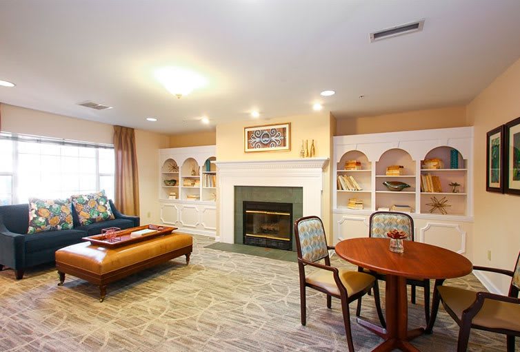 A cozy living room featuring a fireplace surrounded by built-in bookshelves, with comfortable seating and warm lighting.