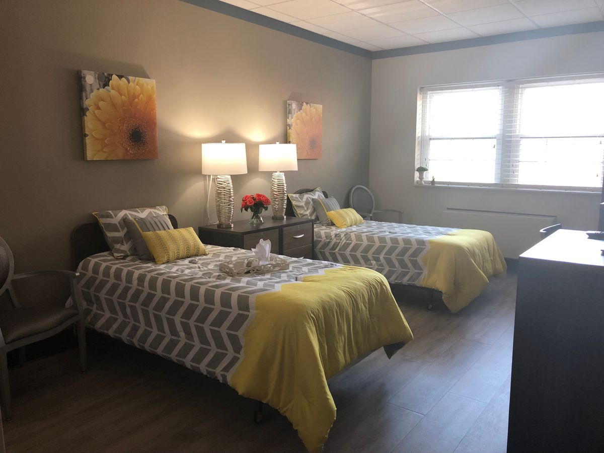 A cozy bedroom featuring twin beds with yellow accents and modern decor.
