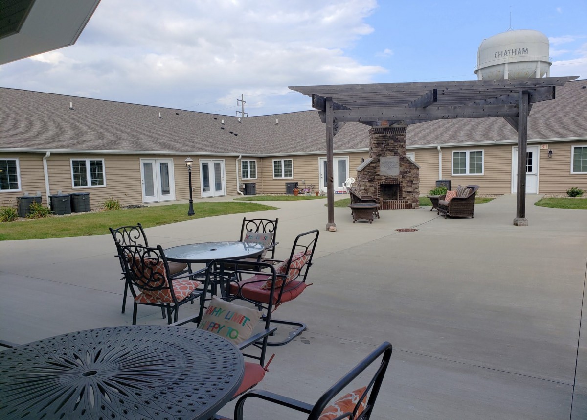 A view of an outdoor courtyard with tables, chairs, and a fireplace.