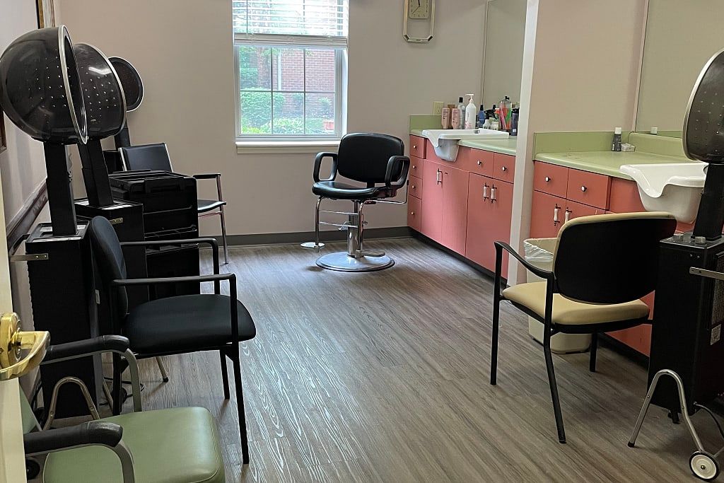 An interior view of a salon with chairs, mirrors, and a window.