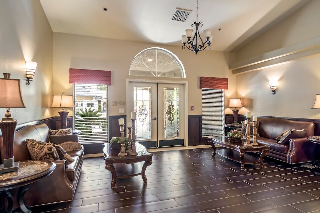 A spacious lobby with elegant furniture and a chandelier.