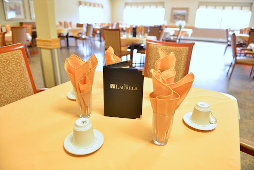 A elegantly set dining table with napkins, coffee cups, and a menu.