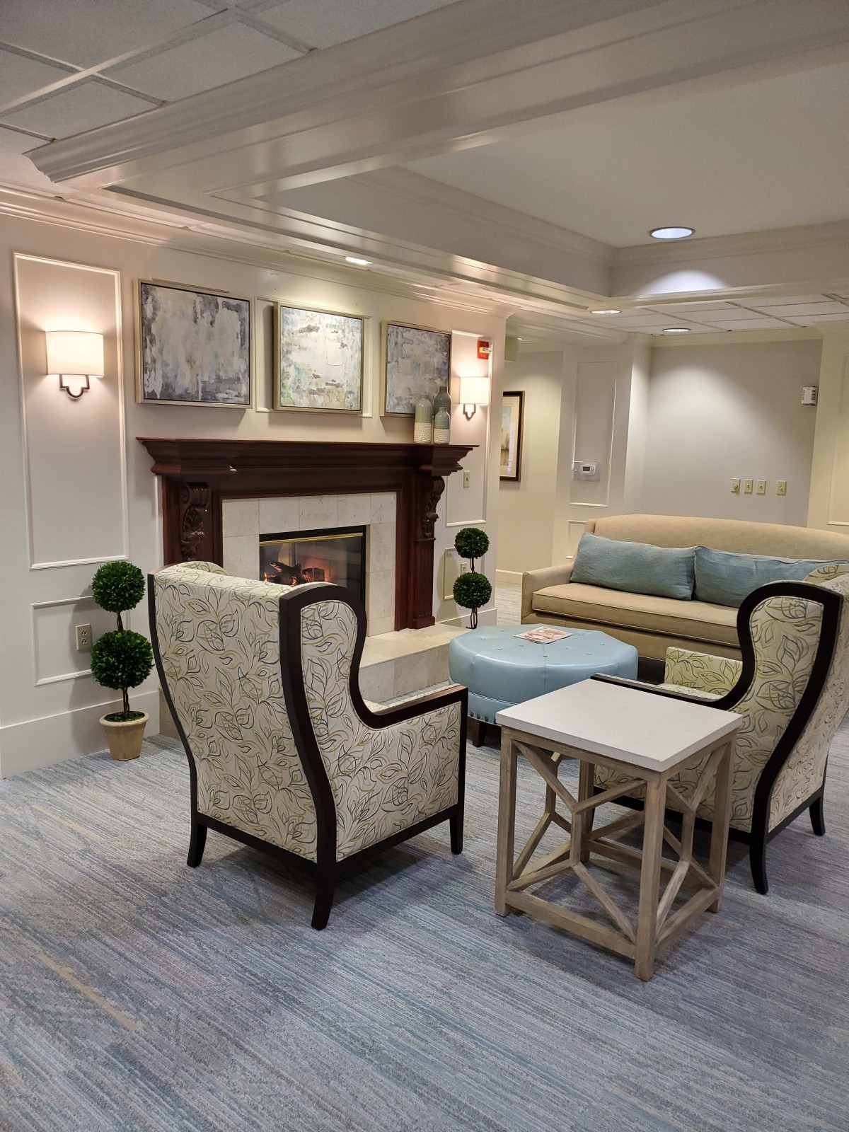 A cozy living room with elegant decor and comfortable seating around a fireplace.