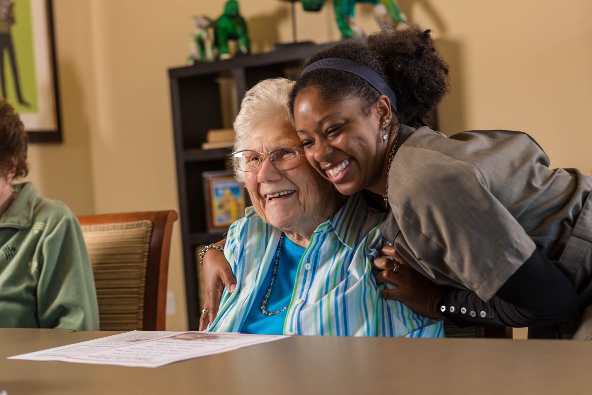 A joyful moment shared between two women as they hug and smile.