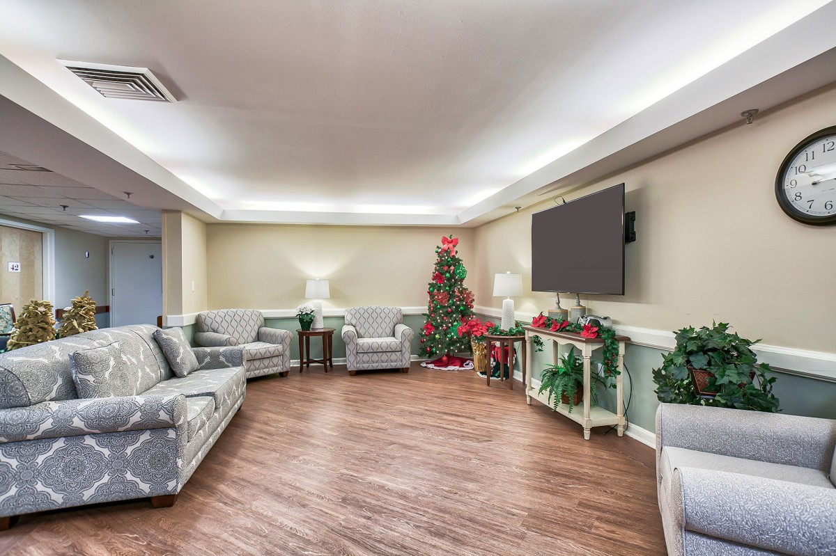 A cozy living room decorated for the holidays with a Christmas tree and comfortable seating.
