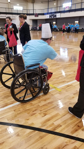 A participant in a wheelchair engages in an indoor recreational activity.