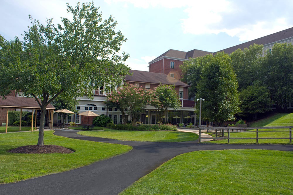 A scenic view of a building surrounded by greenery and a paved pathway.