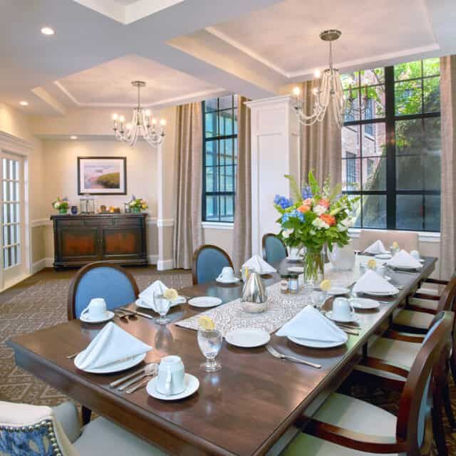 An elegantly set dining room with a luxurious table setting and beautiful floral centerpiece.