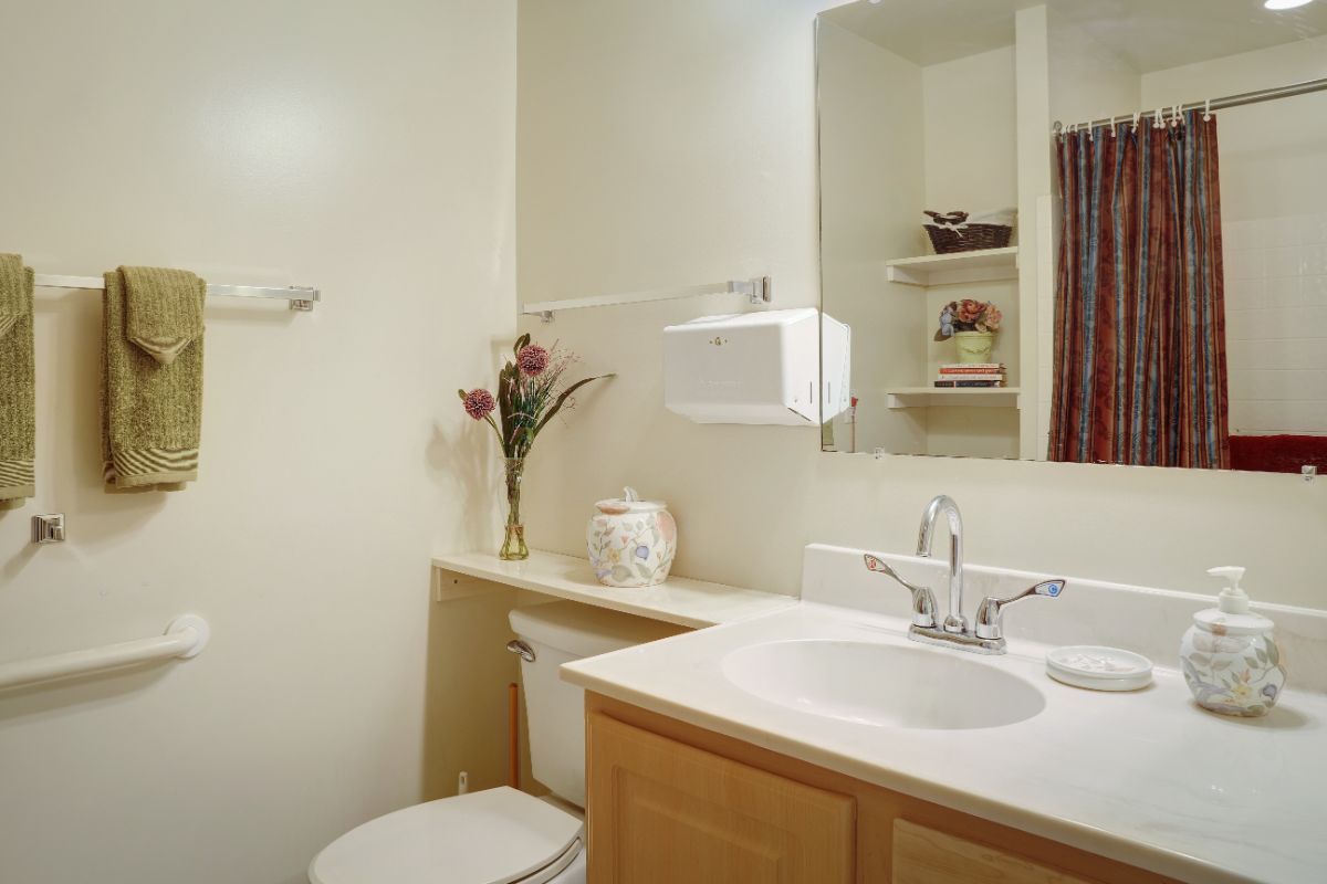 A modern bathroom with a clean sink and mirror, featuring minimal decor.