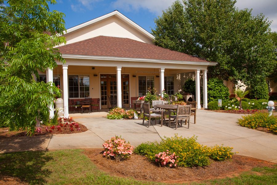 A serene house with a porch and a beautifully landscaped garden.