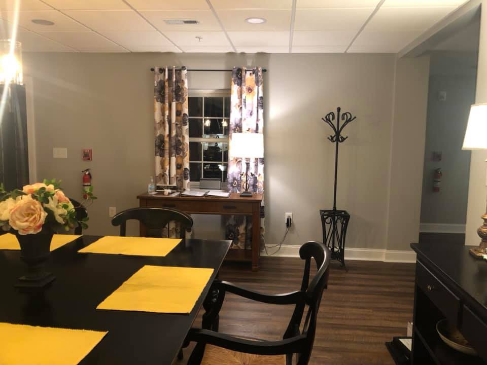 A cozy dining room with a table set for a meal and warm lighting.