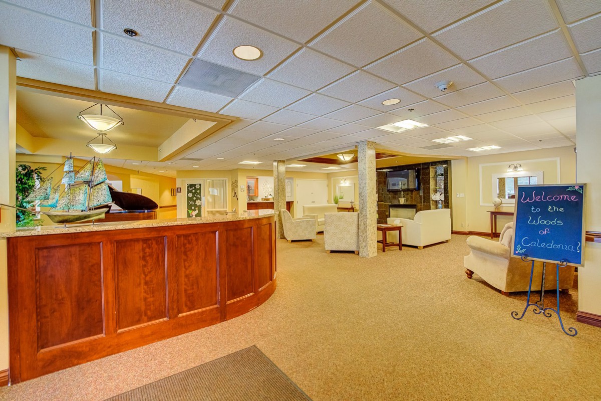 A spacious and welcoming reception lobby with comfortable seating and a wooden front desk.