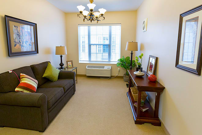 Cozy living room with a sofa, lamps, and bright natural light.