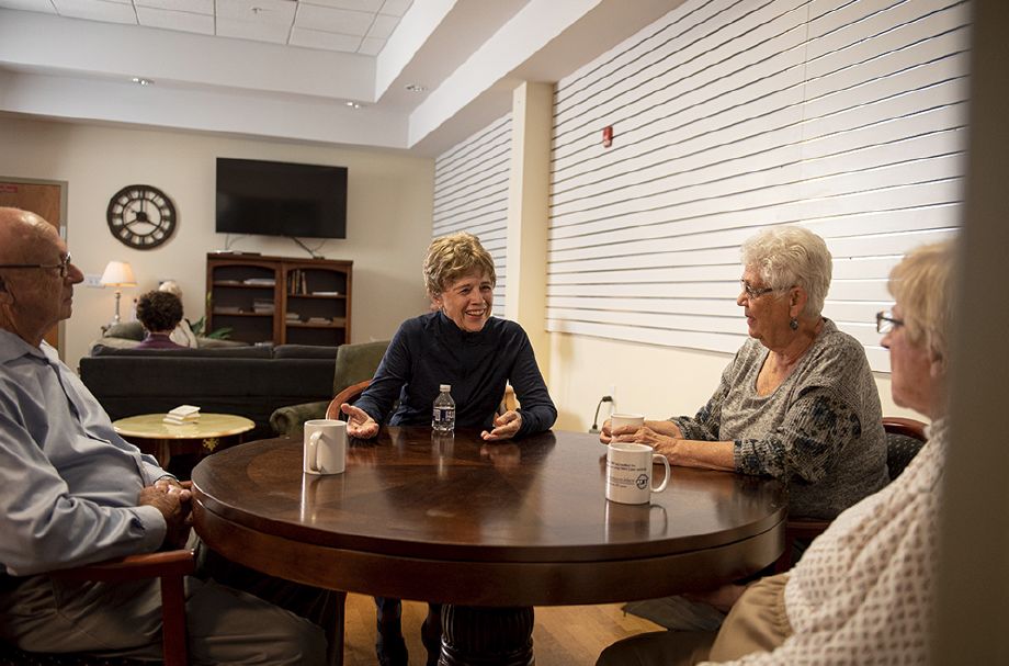 A group of people engaged in a discussion around a table indoors.