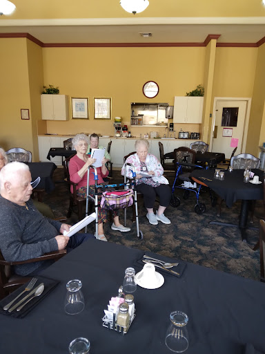A group of senior citizens engaged in a social gathering at a community center, enjoying each other's company.
