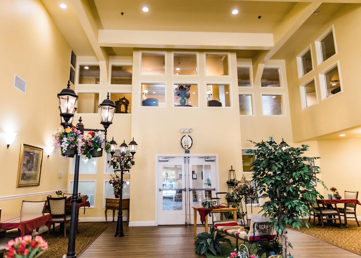 A warmly lit lobby with decorative street lamps, plants, and comfortable seating.