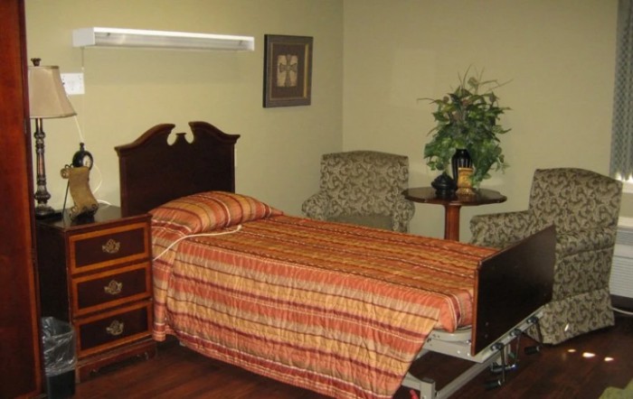 A cozy bedroom with a single bed, nightstand, and decorative items.
