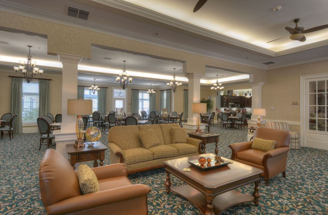A spacious and well-furnished living room with sofas, chairs, and a coffee table.