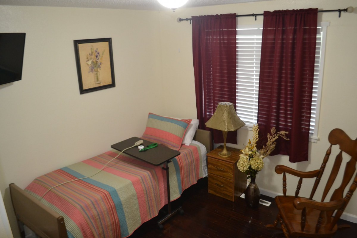 A cozy bedroom with a single bed, nightstand, and decorative elements.